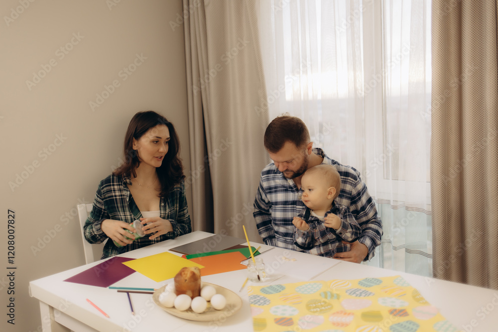 A young family with their young son enthusiastically paints Easter eggs, creating fond memories and continuing ancient traditions A young family with their young son enthusiastically paints Easter eggs, creating fond memories and continuing ancient traditions