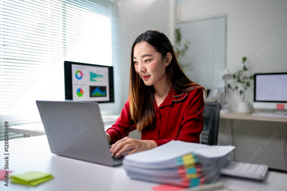 A woman is sitting at a desk with a laptop and a stack of papers A woman is sitting at a desk with a laptop and a stack of papers