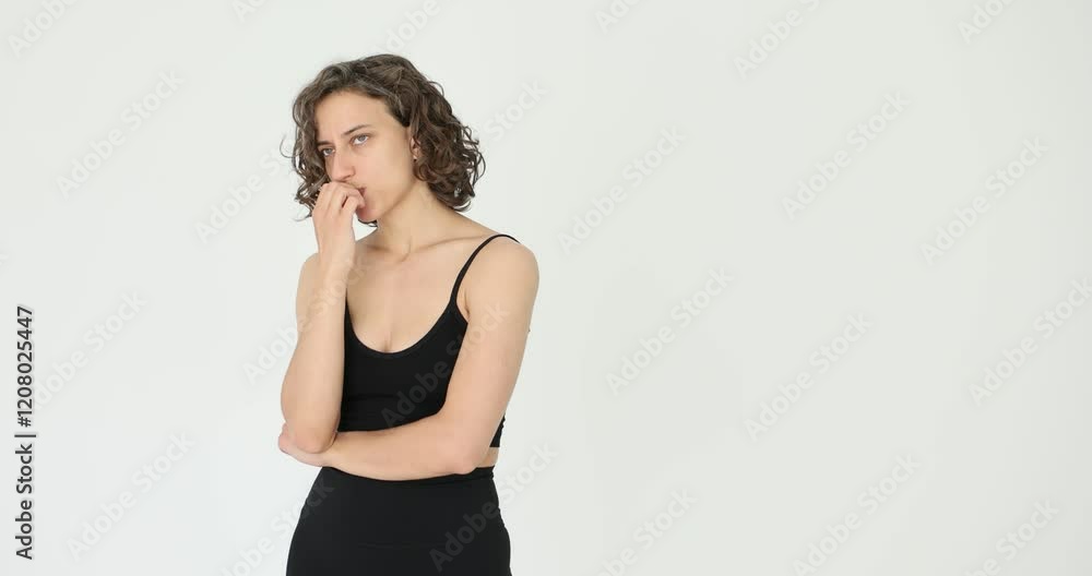 Woman thoughtfully biting her nails on a white background Woman thoughtfully biting her nails on a white background