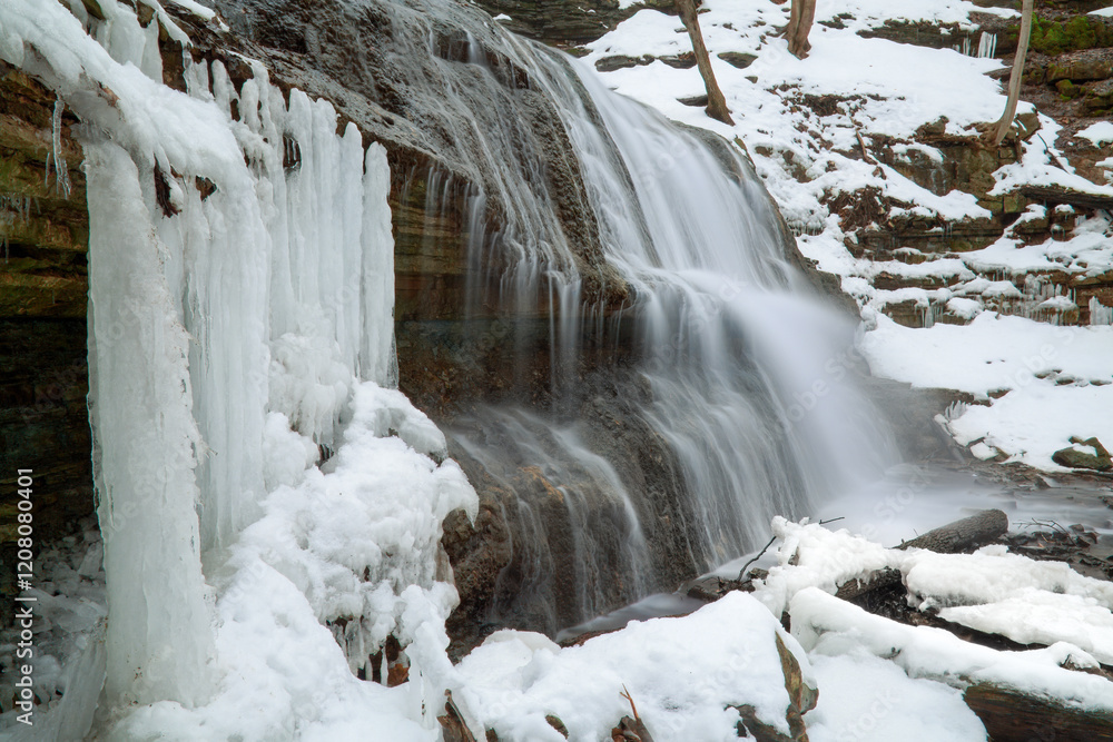 A long exposure blurred motion gorgeous cascading waterfall in the late winter, early spring, with melting snow and ice. A long exposure blurred motion gorgeous cascading waterfall in the late winter, early spring, with melting snow and ice.