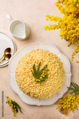Top view of Mimosa cake - traditional Italian sponge cake for celebration of the 8th of March, International Womens Day. Breakfast table with flowers, vertical image.
