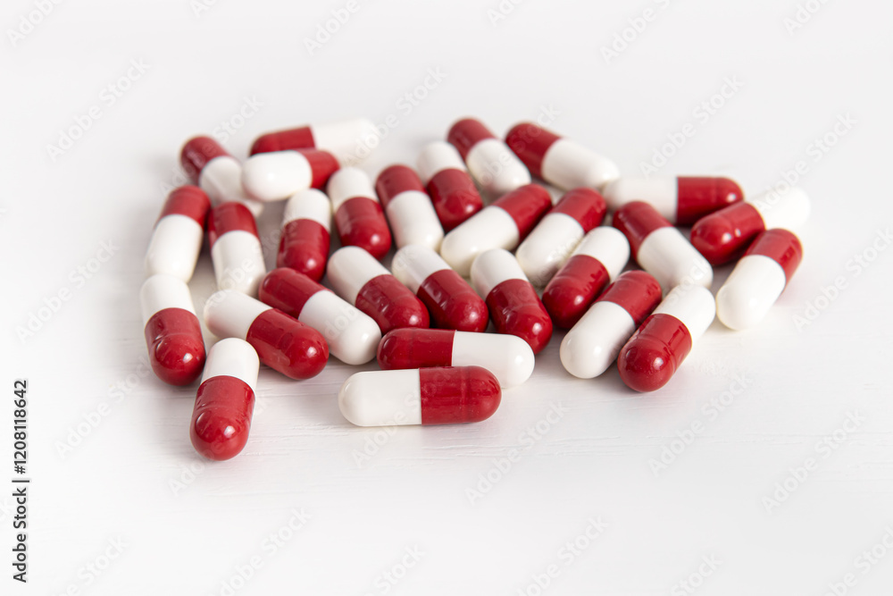 Handful of two-colors capsules on white background. Red and white capsules pills Handful of two-colors capsules on white background. Red and white capsules pills