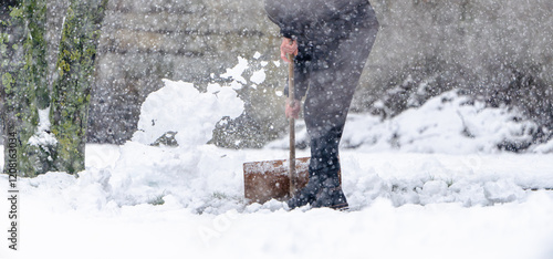 A man shovels snow with a shovel