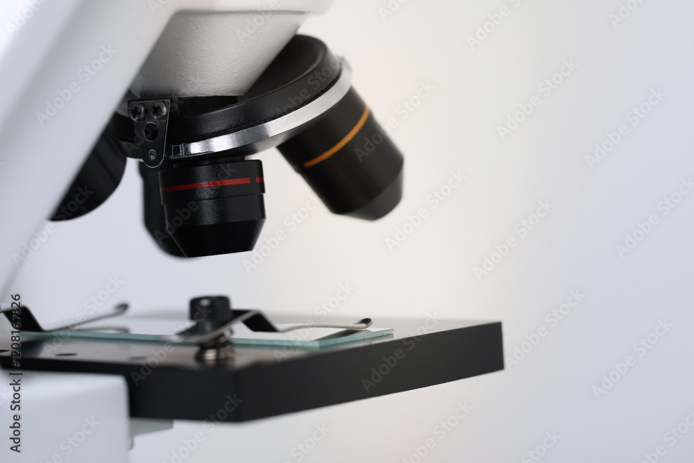 Science. Microscope with glass slide on light grey background, closeup Science. Microscope with glass slide on light grey background, closeup