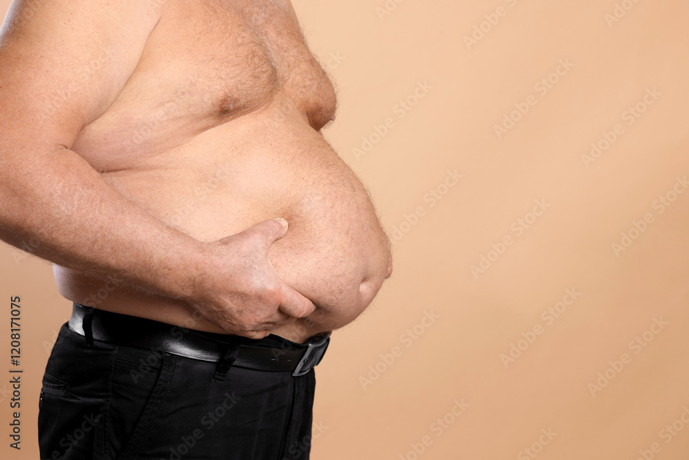 Naklejka premium Overweight problem. Man with excessive belly fat on beige background, closeup. Space for text