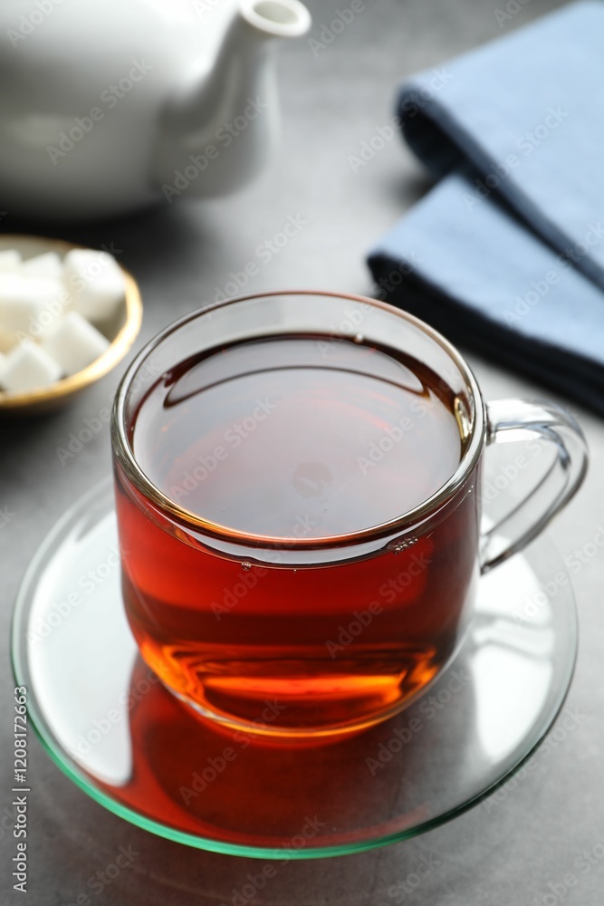 Refreshing black tea in cup on grey table, closeup Refreshing black tea in cup on grey table, closeup