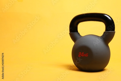 One heavy kettlebell on yellow background. Space for text photo