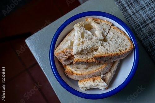 A bowl of sliced Alentejo bread, ready to be added to the traditional Portuguese tomato soup, showcasing rustic and authentic flavors. photo