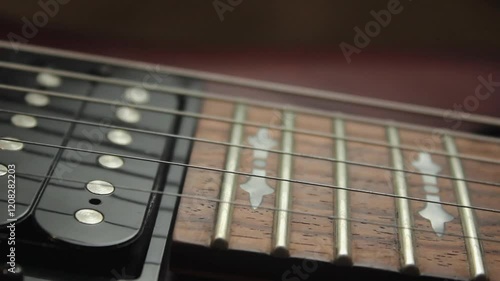 The human hand with pick plays chords the electric guitar. Vibration of metal strings