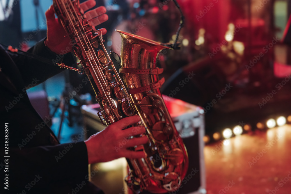 Concert view of saxophonist musician, saxophone sax player with vocalist and musical band during jazz orchestra show performing music on a stage in the scene lights, concert in a musical club hall