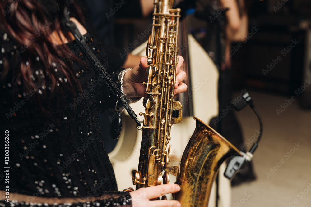 Concert view of female saxophonist musician, saxophone sax player woman with vocalist and musical band during jazz orchestra show, performing music on a scene in the stage lights in a musical club Concert view of female saxophonist musician, saxophone sax player woman with vocalist and musical band during jazz orchestra show, performing music on a scene in the stage lights in a musical club