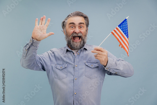 Enthusiastic senior man waving and holding United States flag photo