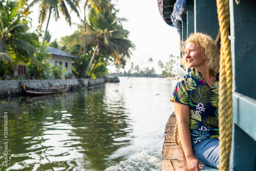 Fotografía European tourist having a traditional straw houseboat ride on the backwaters of