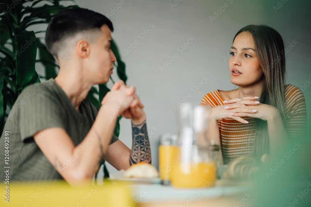 Lesbian couple having breakfast and talking at home Lesbian couple having breakfast and talking at home
