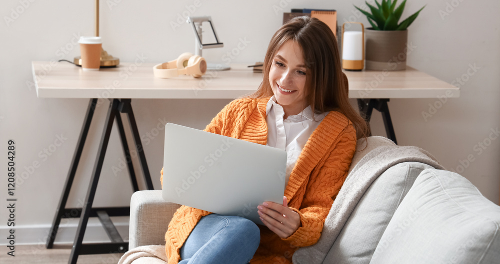 Young woman with laptop video chatting on sofa at home Young woman with laptop video chatting on sofa at home