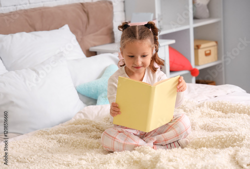 Cute little girl reading bo...