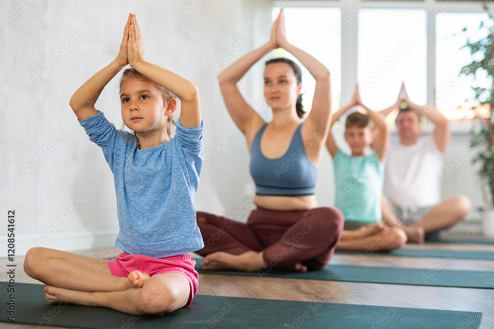 Mom with her family practices yoga in the lotus position Mom with her family practices yoga in the lotus position