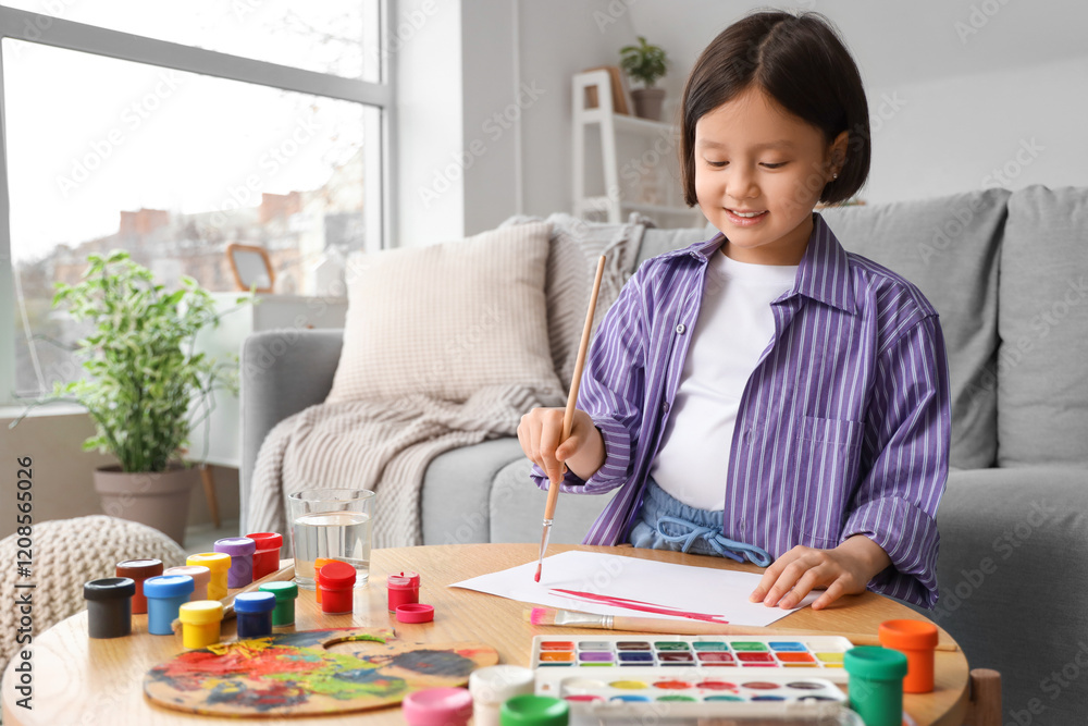 Cute Asian girl with brush painting on table at home Cute Asian girl with brush painting on table at home