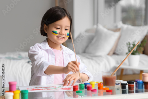 Cute Asian girl painting at...