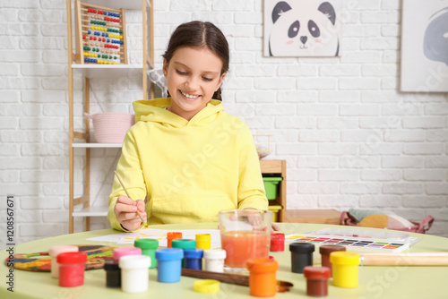 Cute girl painting on table...