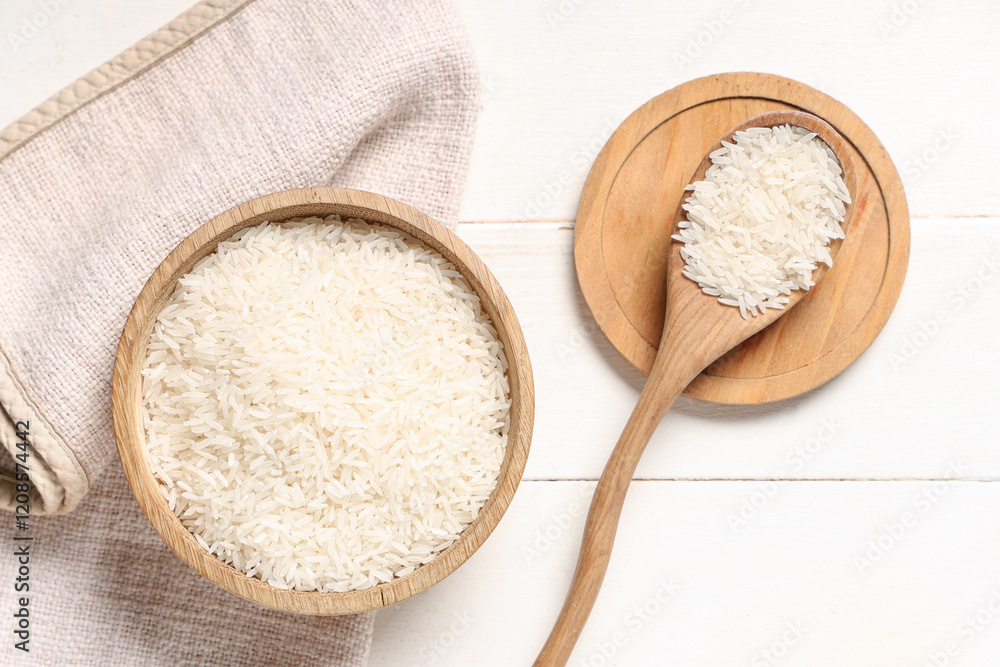 Bowl and spoon with raw rice on white wooden background Bowl and spoon with raw rice on white wooden background