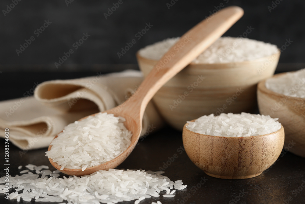 Wooden bowls with raw rice and spoon on black grunge background Wooden bowls with raw rice and spoon on black grunge background