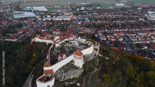Drone circling the Râșnov Fortress captures its unique structure, nestled perfectly among green hills and offering a glimpse into medieval history.