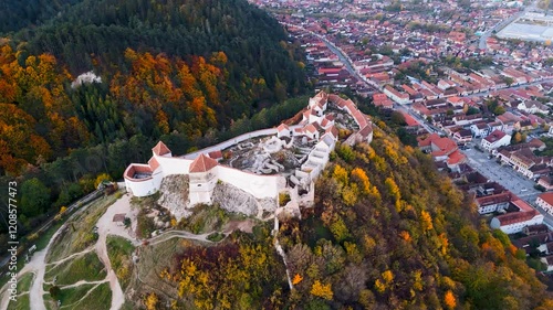 High-resolution drone footage showcasing the Râșnov Fortress as it stands proudly amidst a dramatic landscape of forests and mountains.