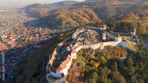 High-resolution drone footage showcasing the Râșnov Fortress as it stands proudly amidst a dramatic landscape of forests and mountains.