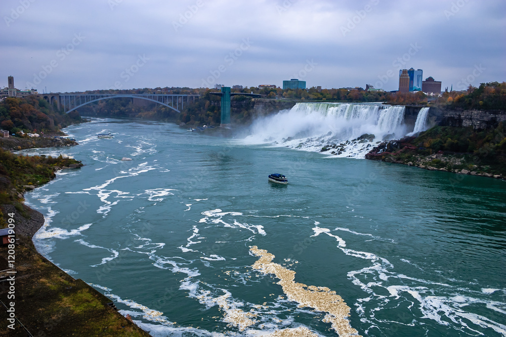 A boat is floating on a river with a waterfall in the background A boat is floating on a river with a waterfall in the background