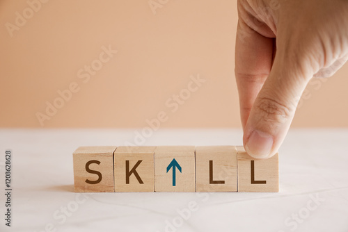 Hands holding wooden blocks with UP SKILL, self improvement business concept