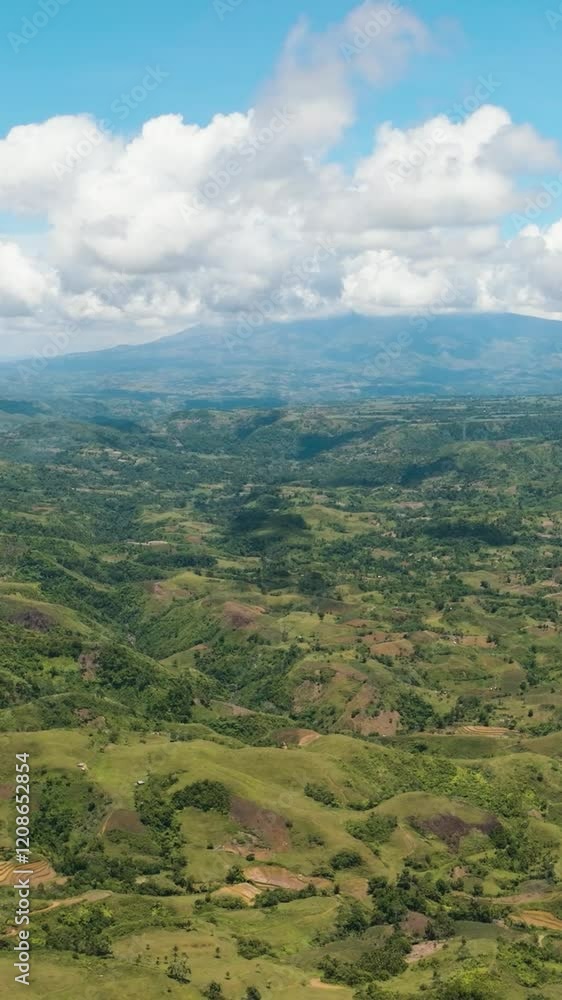 Top view of farmland on a background of blue sky and clouds in a mountainous area. Negros, Philippines Top view of farmland on a background of blue sky and clouds in a mountainous area. Negros, Philippines