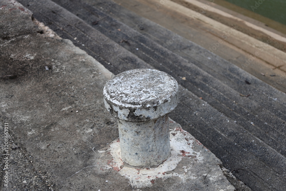 concrete boat mooring station needing fresh paint above worn concrete steps down to water's edge concrete boat mooring station needing fresh paint above worn concrete steps down to water's edge