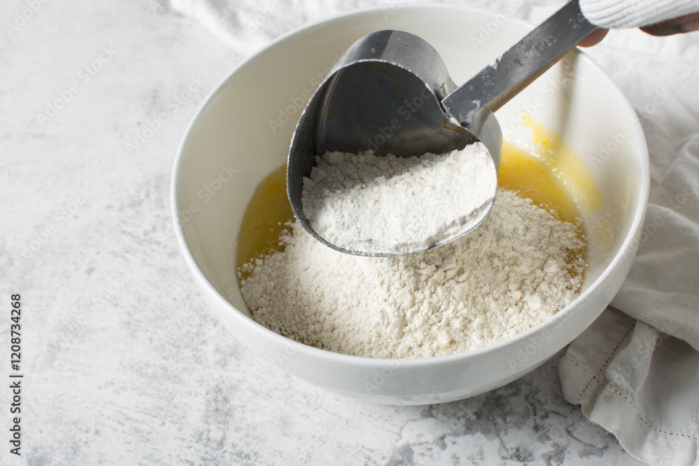 overhead view of All purpose flour in a measuring cup, baking flour in a steel measuring cup overhead view of All purpose flour in a measuring cup, baking flour in a steel measuring cup