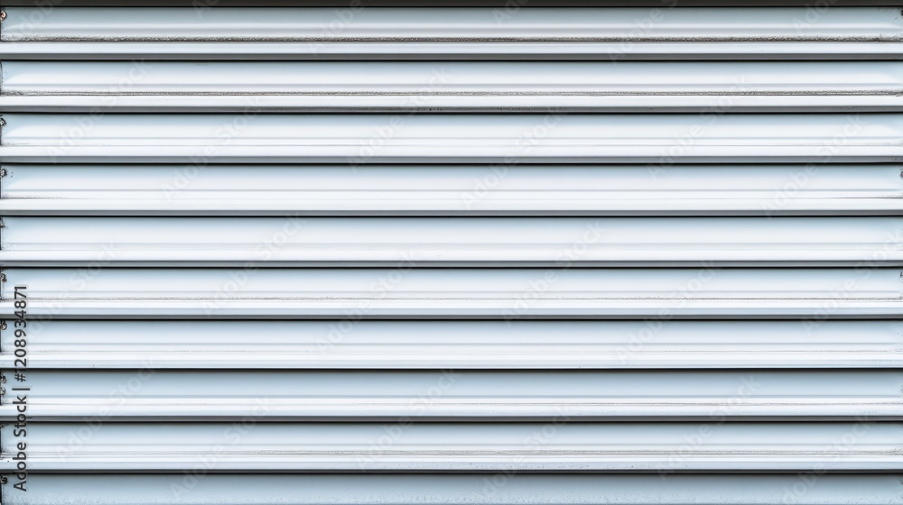 Close-up of a modern, sleek metallic roller shutter design for industrial use. Close-up of a modern, sleek metallic roller shutter design for industrial use.