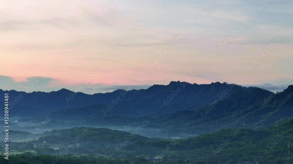Aerial shot panning right, featuring silhouette of a mountain landscape in Indonesia. Menoreh hills. 4K drone view. Aerial shot panning right, featuring silhouette of a mountain landscape in Indonesia. Menoreh hills. 4K drone view.