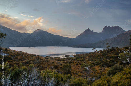 Serene dawn at Dove Lake with Cradle Mountain peaks, tranquil reflections, and misty clouds in Tasmania, Australia photo