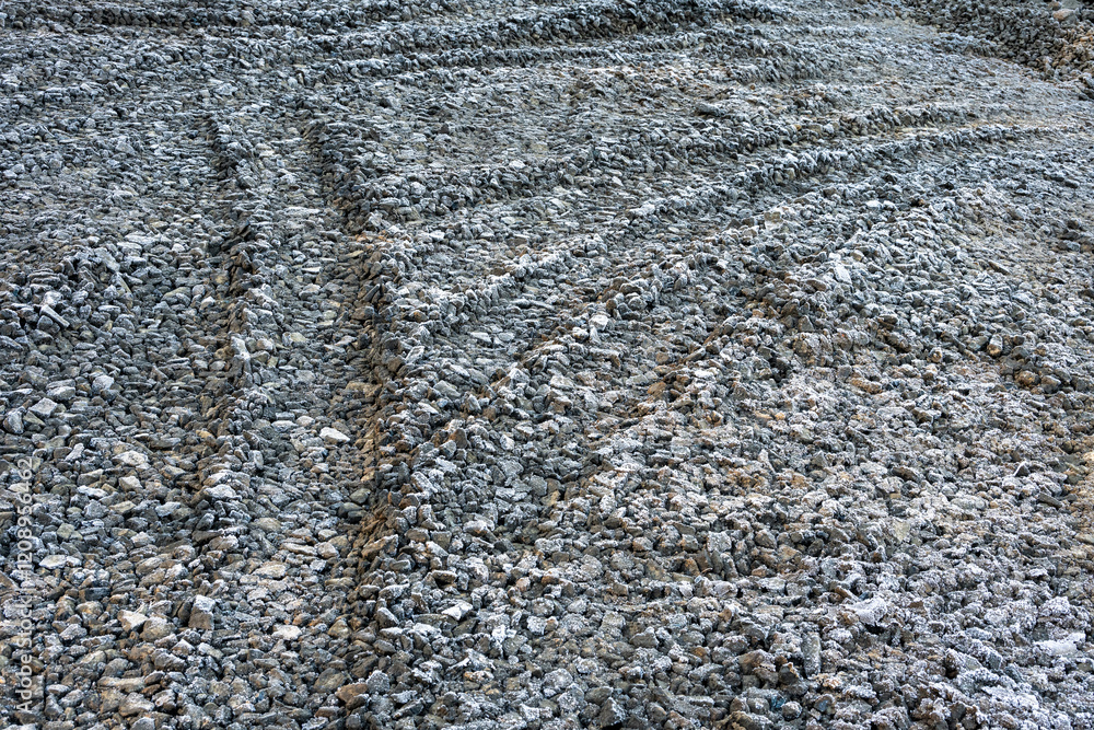 Gravel parking area on new construction lot, frosty and frozen tire tracks early on a winter morning
Gravel parking area on new construction lot, frosty and frozen tire tracks early on a winter morning