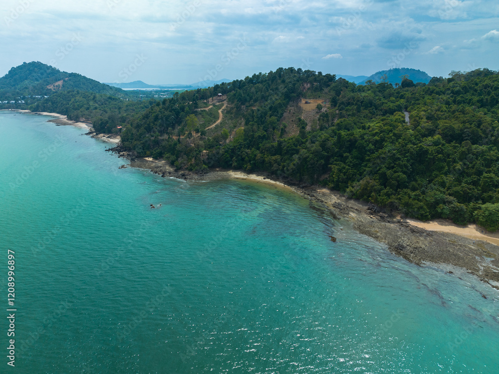 A breathtaking aerial view of a lush green coastline with winding paths, crystal-clear turquoise waters, and distant islands under a partly cloudy sky. Lam Nga is in Silay island Phuket. green sea A breathtaking aerial view of a lush green coastline with winding paths, crystal-clear turquoise waters, and distant islands under a partly cloudy sky. Lam Nga is in Silay island Phuket. green sea