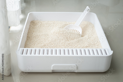 Closeup to a sandbox with cat litter sand flakes and shovel
