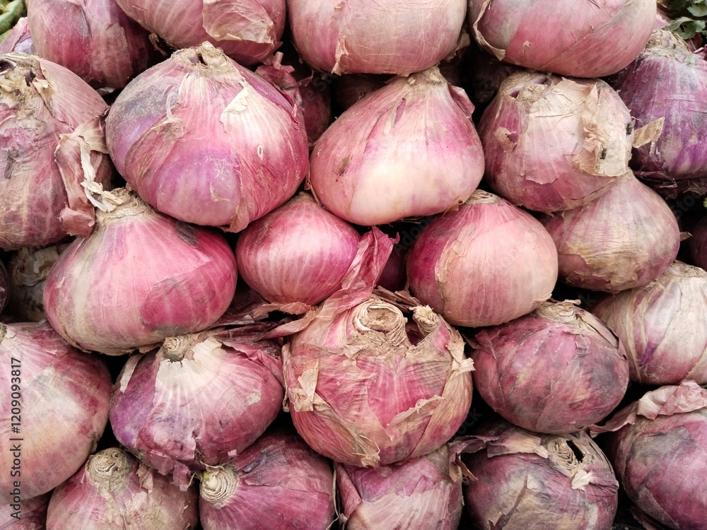 Pile of fresh organic red onions arranged closely, showcasing their natural texture and vibrant color, ideal for agriculture, cooking, and market concepts. Pile of fresh organic red onions arranged closely, showcasing their natural texture and vibrant color, ideal for agriculture, cooking, and market concepts.