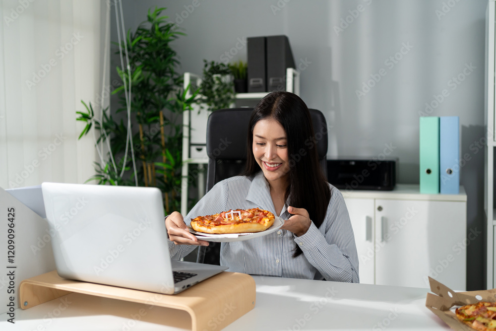Asian young businesswoman eating homemade pizza while working in office. Asian young businesswoman eating homemade pizza while working in office.