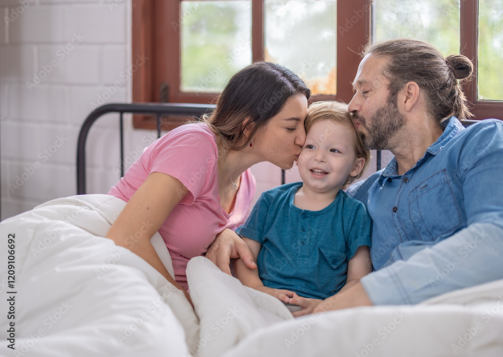Family enjoying a cozy morning together in bed with warm blankets and natural light Family enjoying a cozy morning together in bed with warm blankets and natural light