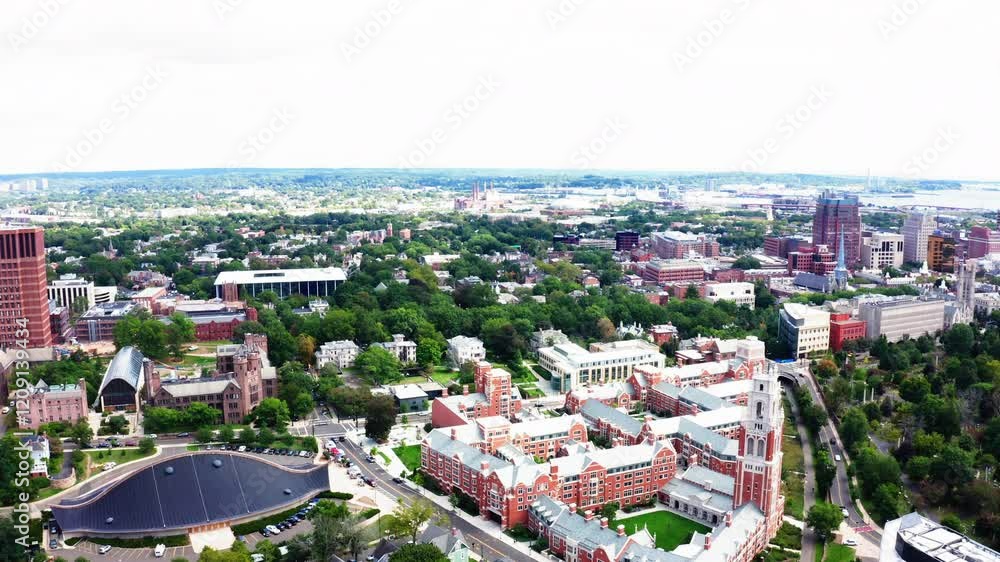Fly-out drone view of New Haven, Connecticut, capturing the city’s architectural blend and vibrant greenery from a stunning aerial perspective. Fly-out drone view of New Haven, Connecticut, capturing the city’s architectural blend and vibrant greenery from a stunning aerial perspective.
