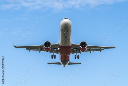 Obraz na płótnie Airplane flying overhead against a clear blue sky near the airport during the day w salonie