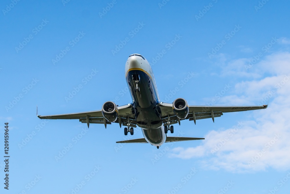 Airliner prepares for landing above a clear blue sky in an urban area during daytime Airliner prepares for landing above a clear blue sky in an urban area during daytime
