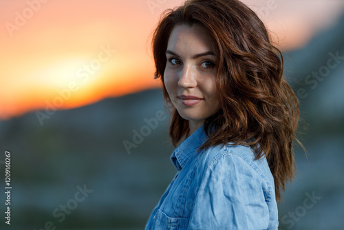 Photos Young woman smiles at sunset while standing outdoors in nature