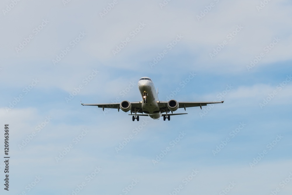 Airplane flying through clear blue skies above a scenic landscape during daylight hours Airplane flying through clear blue skies above a scenic landscape during daylight hours