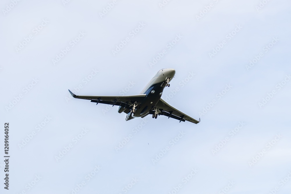 Commercial jet aircraft approaches landing over clear blue sky in mid-afternoon hours at the airport