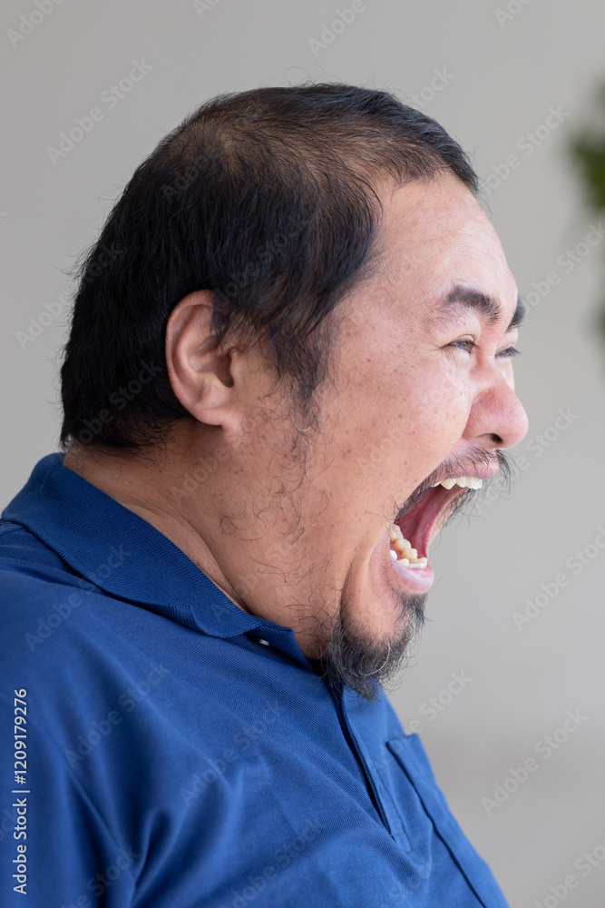 Obraz premium Angry, upset, middle aged Asian man shouting, screaming out loud to his side way